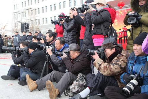 图为摄影家协会的会员们在社火现场拍摄 图为摄影家协会的会员们在社火现场拍摄