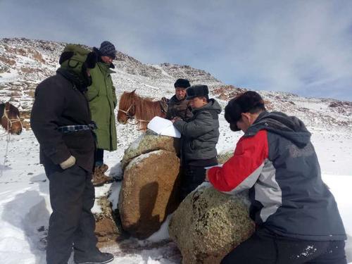 驻村工作队巡回在牧区草场，逐一填写建档立卡户核查认定表