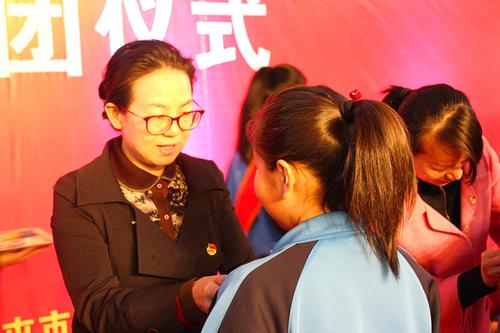 十师北屯市党委常委、纪委书记谷金花为新团员戴团徽