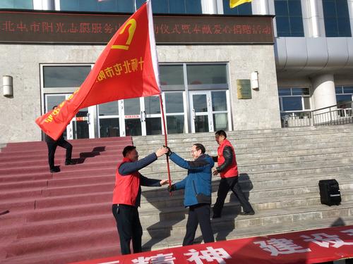 2师市文明办向十师北屯市阳光志愿服务中心授旗
