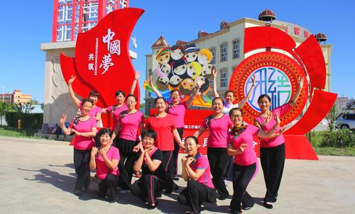 7月3日，得仁社区舞蹈队演员在市区新落成的民族团结主题大型宣传牌前排练节目 唐梓伟摄