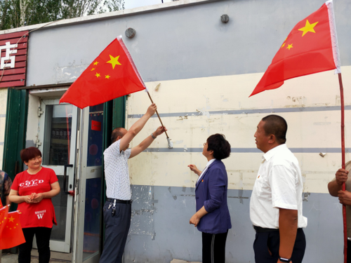 十师党委网信办为村商铺更换悬挂国旗