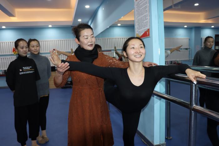 12月9日在第十师秦剧团排练厅里团长宁向红正在给哈萨克族舞蹈演员阿依沙吾列·加尔很传授舞蹈技巧。在这群民族孩子心目中，宁向红既像老师，更像可亲可敬的妈妈。