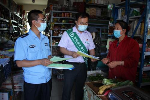 图为：普法办工作人员向群众讲解法治案例