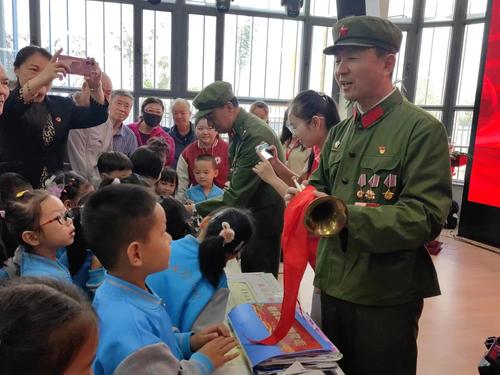 老兵向孩子们展示红色物件