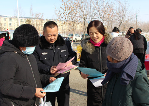 图1：宣传人员在集市向老年人发放非法集资相关内容的宣传资料。衣敏摄