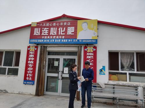 图为185团司法所干警让购买农资职工普及法律知识