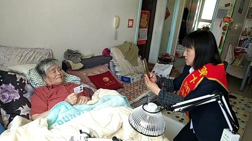 183团社保所工作人员邵惠给退休人员冯爱芳（瘫痪）提供上门认证服务