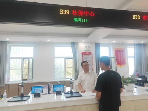 图为社保经办人员为前来办事群众解释社保政策