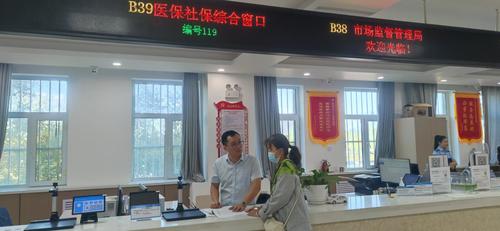 图为政务服务大厅社保窗口工作人员向办事群众解答退休政策