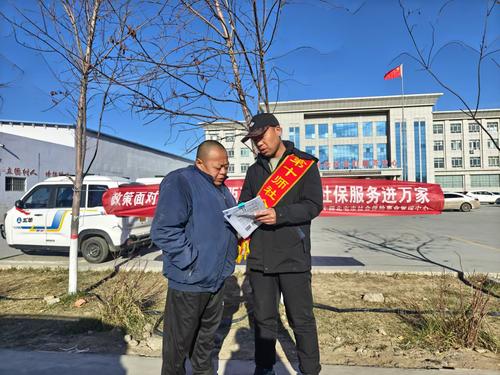 图为11月18日十师188团社保所工作人员在社区门口为路过群众讲解社保政策