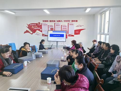 图为十师工作人员袁涛在街道活动室为居民讲解社保惠民政策