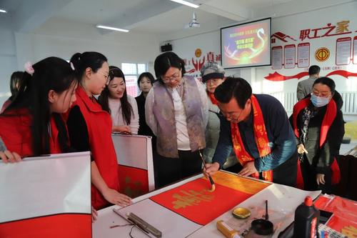 一八七团四连职工们正在围观书法老师写福字