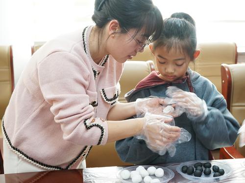图为2月12日，十师社保中心职工和职工家小朋友正在包汤圆