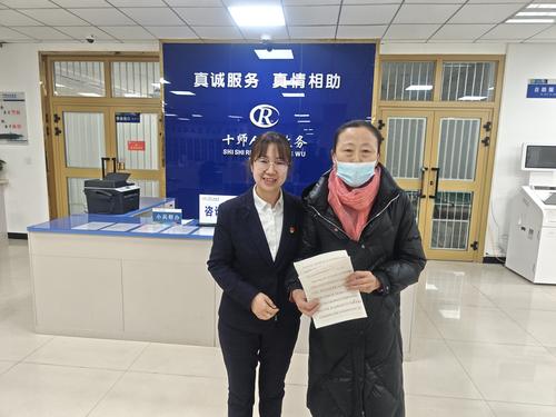 图为2月20日第十师社保中心工作人员袁涛（左）收到办事群众送来的手写感谢信。