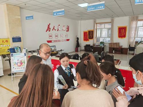图为184团社保所联合农行184团支行工作人员宣传社保政策