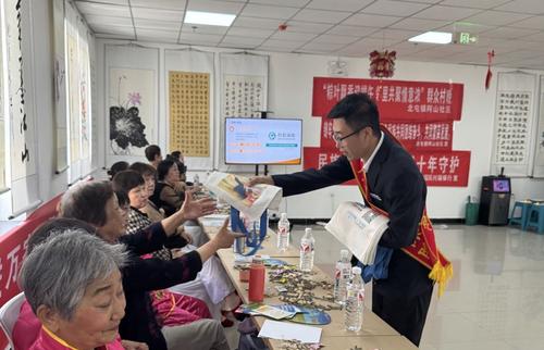 图为社保工作人员化身“社保政策讲解员”向群众宣传社保政策。