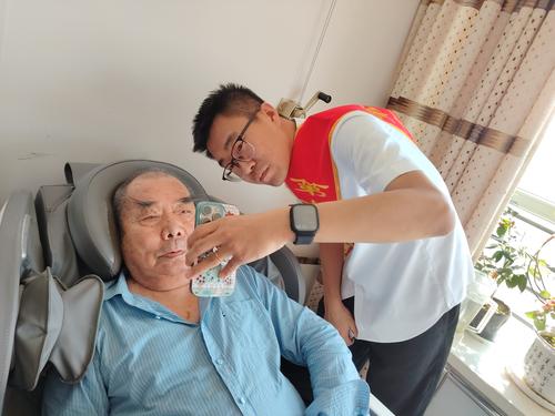 图为社保中心业务人员为86岁的陈爷爷提供上门认证服务