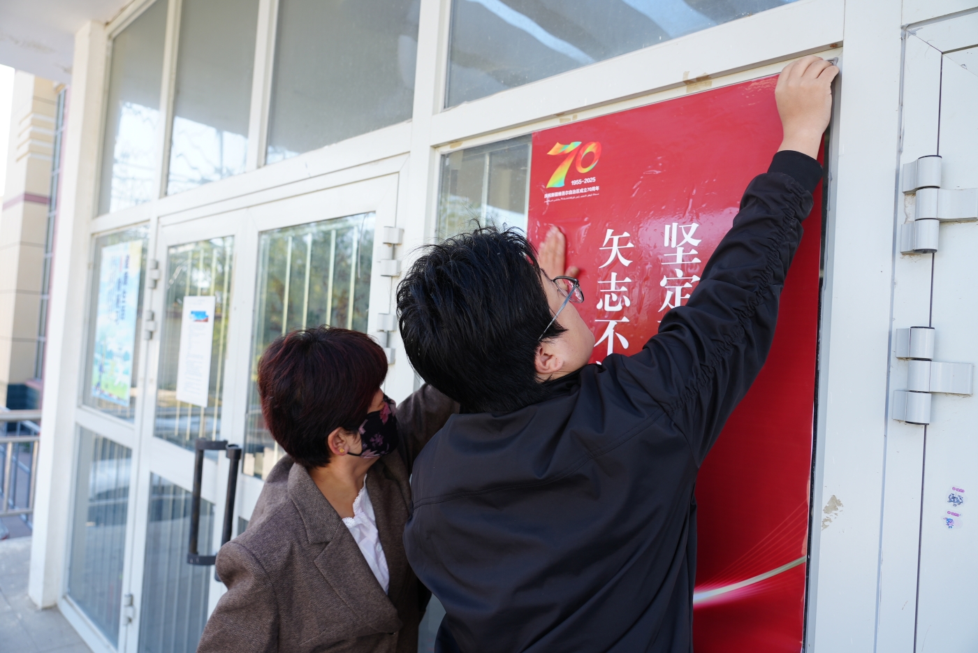 贴海报。谢国庆摄