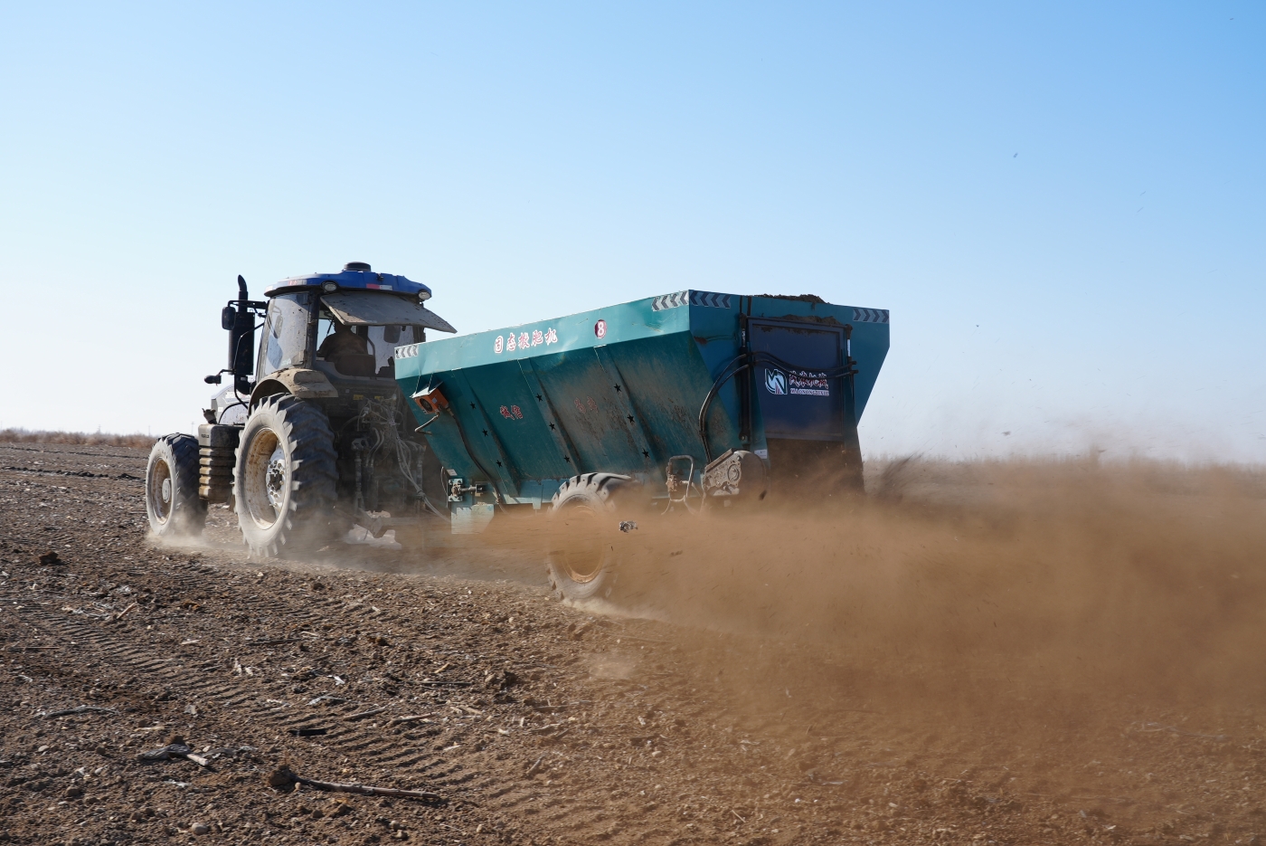 撒肥机正在地里撒施有机肥。谢国庆摄