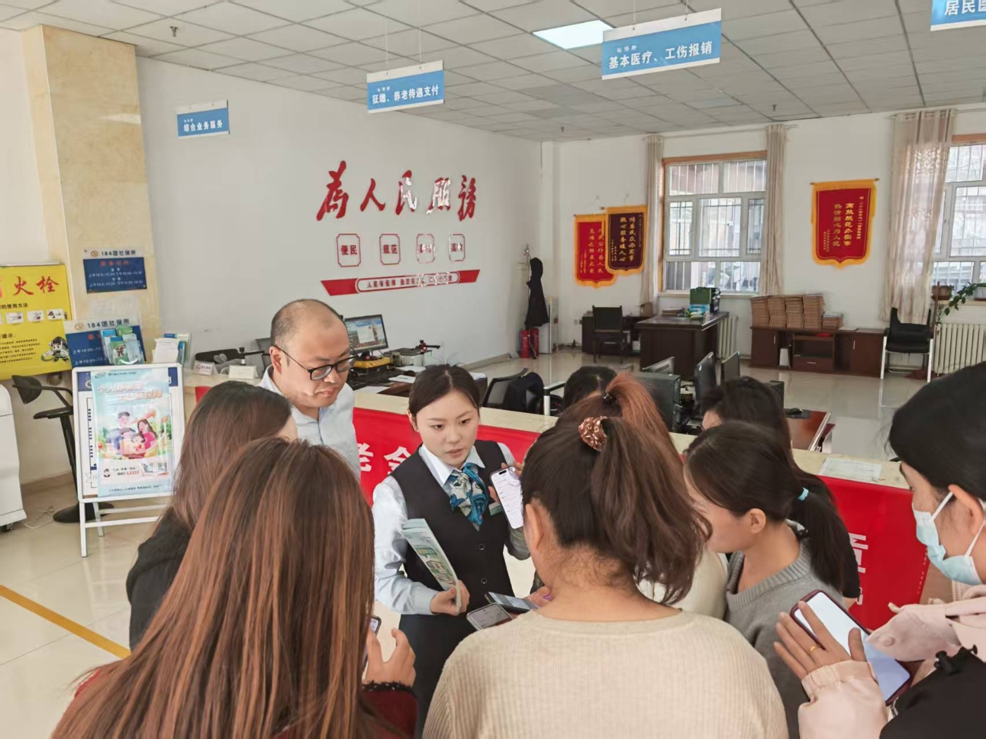 图为工作人员向职工群众介绍电子社保卡小程序的功能