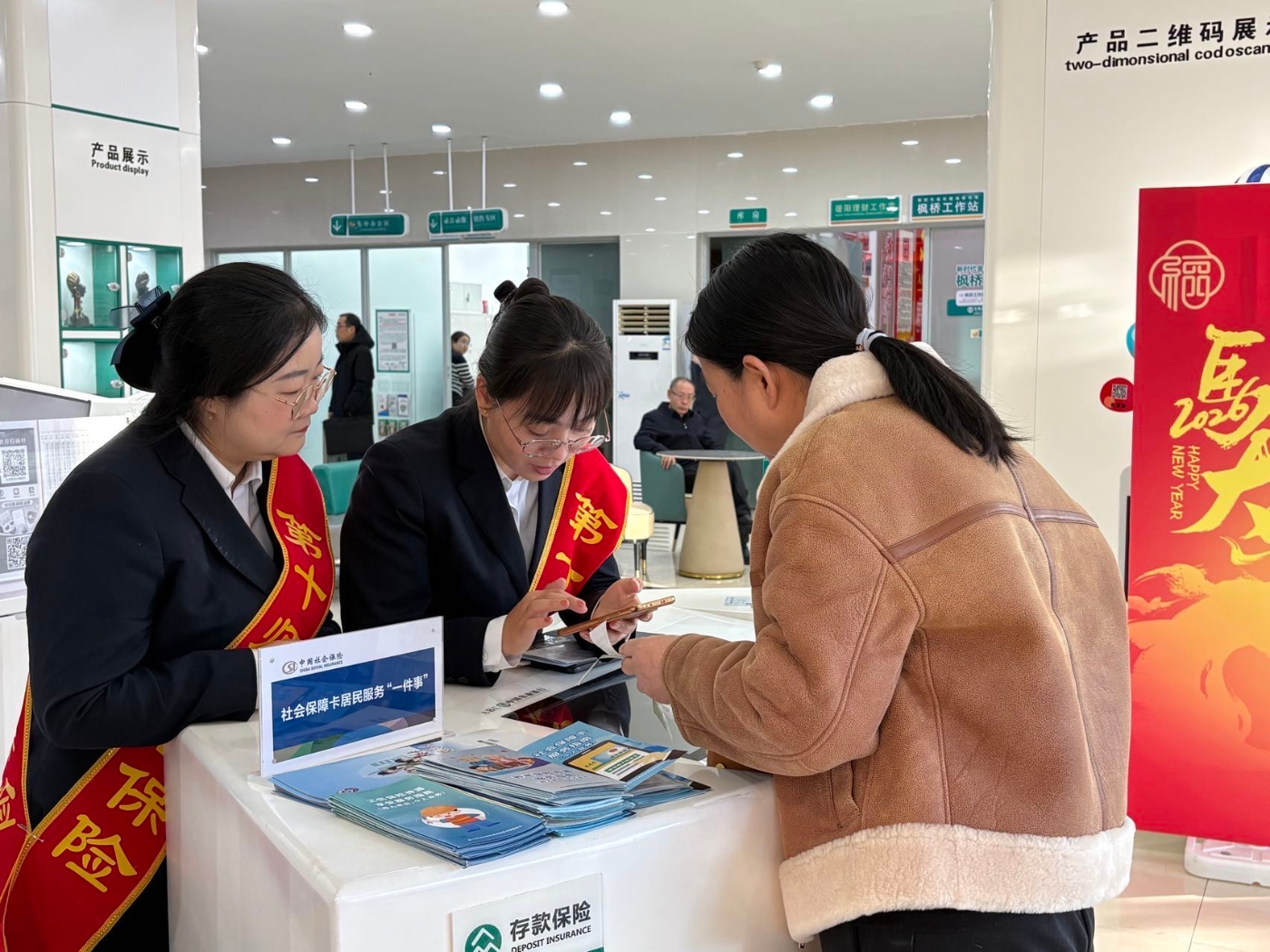 图为在室内服务专区，工作人员“面对面”为群众办理社保卡申领、换发、激活等业务