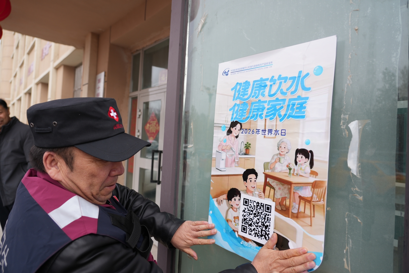 工作人员在张贴“世界水日”宣传海报。谢国庆摄