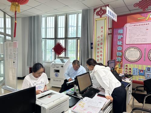 图为工作人员指导参保群众使用小程序缴费