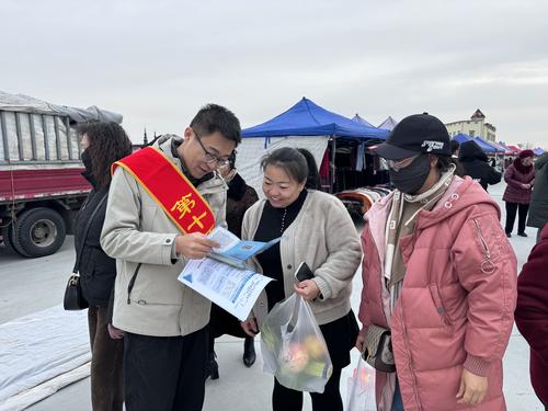 图为11月21日十师188团社保所工作人员在赶集日为居民讲解社保政策